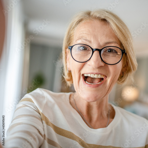 Portrait of one mature blonde caucasian woman with eyeglasses at home