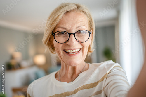 Portrait of one mature blonde caucasian woman with eyeglasses at home