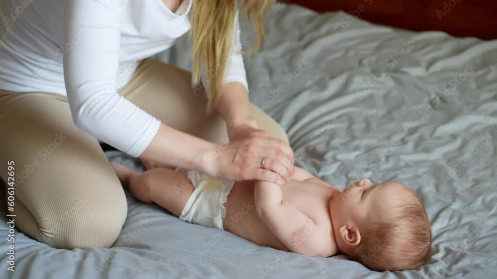 Mom does an exercise to the baby,flexion and extension of the arms. The concept of babysitting,maternity leave,masseur. Mom does an exercise to the baby,flexion and extension of the arms. The concept of babysitting,maternity leave,masseur.