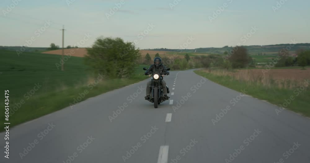 Tracking shot of a man driving speed fast on a vintage motorcycle. Tracking shot of a man driving speed fast on a vintage motorcycle.