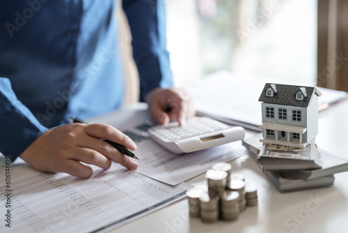 Financial concept, Close up hand with coin stack for house investment, Debt and loan.