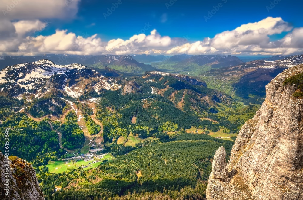Mountain landscape in Austria. View from Loser peak over summits, rocky cliff and village in green valley, Dead Mountains (Totes Gebirge), group of mountains in Austrian Alps.