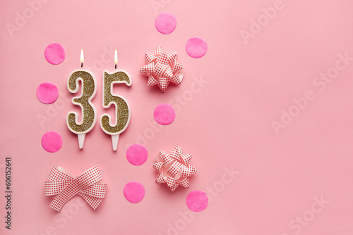 Number 35 on a pastel pink background with festive decor. Happy birthday candles. The concept of celebrating a birthday, anniversary, important date, holiday. Copy space. Banner