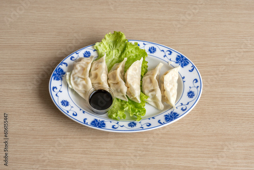 Paris, France - 05 04 2023: Asian dishe culinary Still Life. Thai Gyozas with salads and spicy sauce. photo