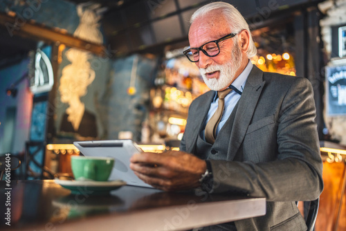 Senior man businessman business owner use digital tablet sit at cafe