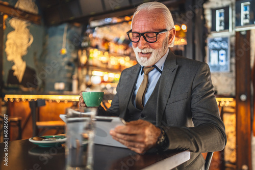 Senior man businessman business owner use digital tablet sit at cafe