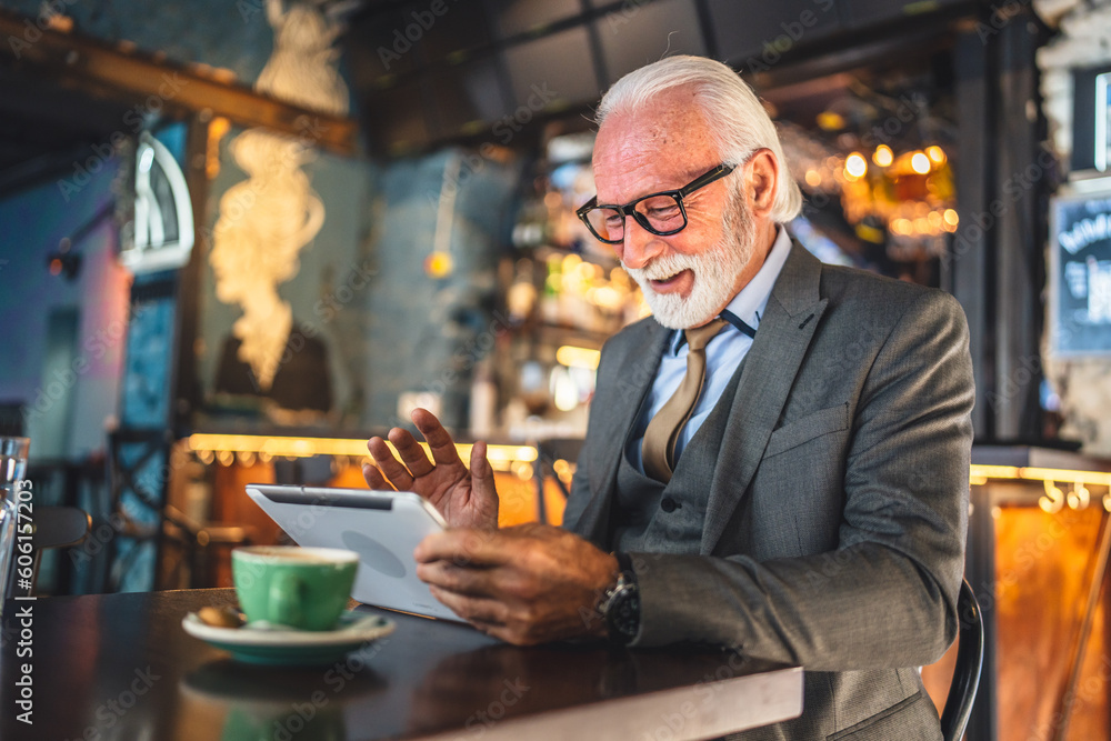Senior man businessman business owner use digital tablet sit at cafe Senior man businessman business owner use digital tablet sit at cafe