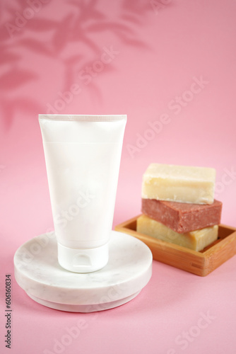 Cosmetic skincare blank container mockups in a styled setting. Pink background with leaves shadow photography. 