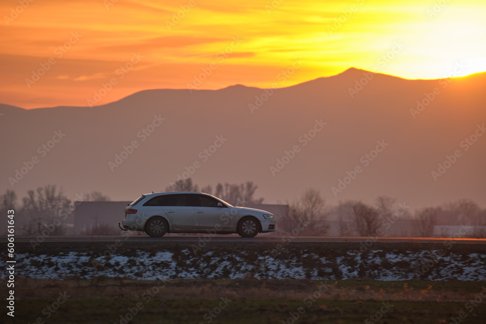 Car driving fast on intercity road at sunset. Highway traffic in evening