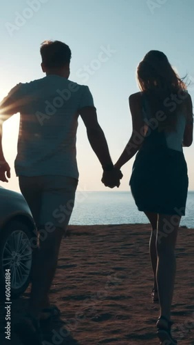 The couple running to the mountain cliff on the sea shore. slow motion