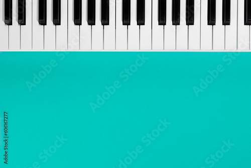 Flat lay background with piano  white synthesizer on blue background  musical keys isolated  top view  copy space.