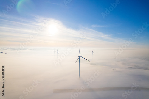 Aerial view of windfarm during winter foggy morning 
