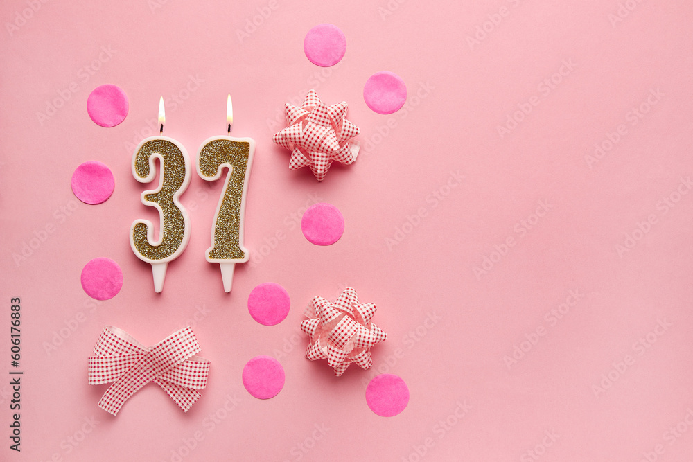 Number 37 on pastel pink background with festive decor. Happy birthday candles. The concept of celebrating a birthday, anniversary, important date, holiday. Copy space. Banner