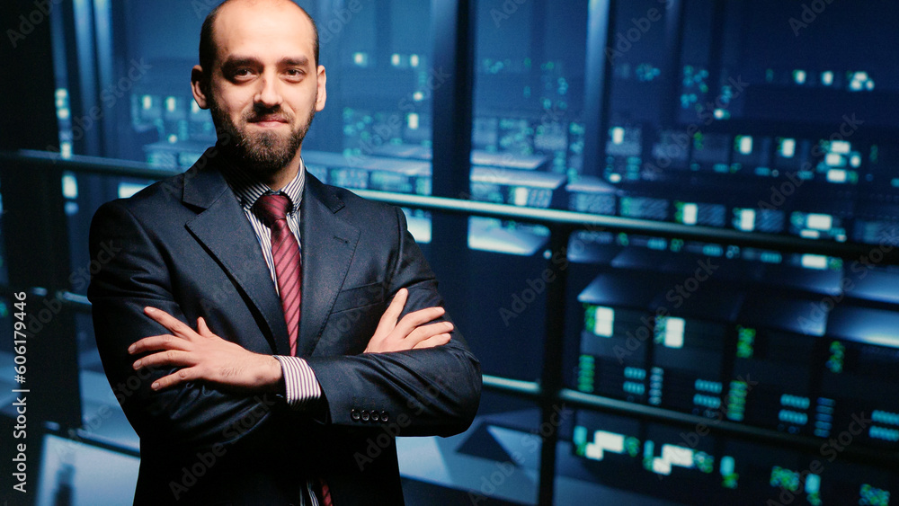 IT engineer standing beside server racks cabinets, checking diagnostics on computer mainframe. System administrator running system check for cloud computing industry, cyber security. IT engineer standing beside server racks cabinets, checking diagnostics on computer mainframe. System administrator running system check for cloud computing industry, cyber security.