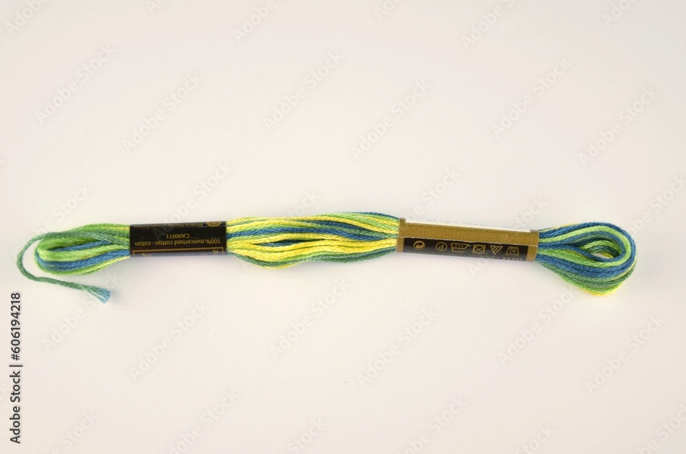 A multi-colored (variegated) skein of mouline thread in green, blue and yellow colours A multi-colored (variegated) skein of mouline thread in green, blue and yellow colours