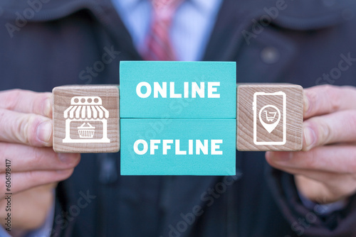 Man holding colorful blocks with icons and inscription: ONLINE OFFLINE. Transition from online to offline or vice versa in commerce, business, retail. Choose between online and offline.