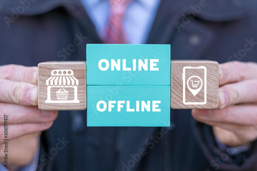 Billede på lærred Man holding colorful blocks with icons and inscription: ONLINE OFFLINE