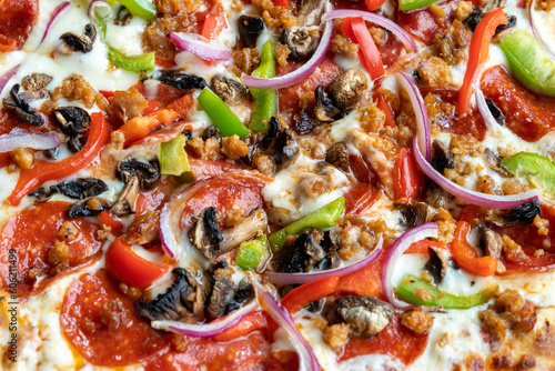 detail of pizza with vegetables, black olives, onion, focus on the upper part of the image