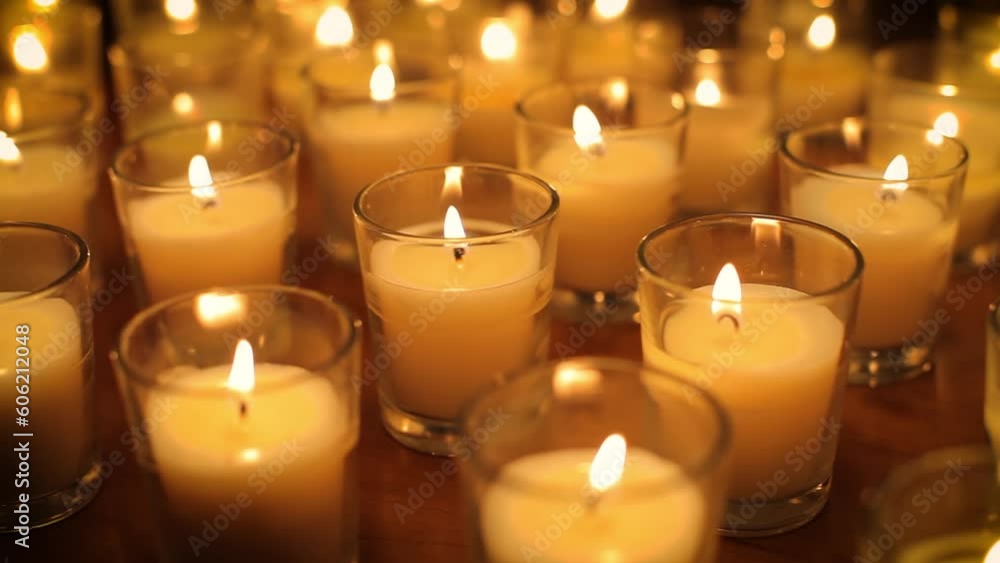 Camera moves past rows of glowing candles in a church or temple. Camera moves past rows of glowing candles in a church or temple.