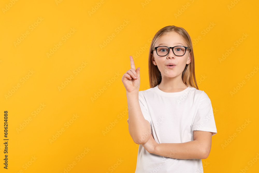 Portrait of emotional girl in glasses on orange background. Space for text