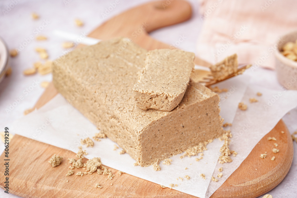 Board with tasty halva and peanuts on white background Board with tasty halva and peanuts on white background