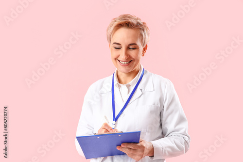 Smiling female doctor writi...