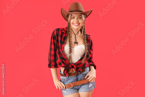 Young cowgirl on red background photo