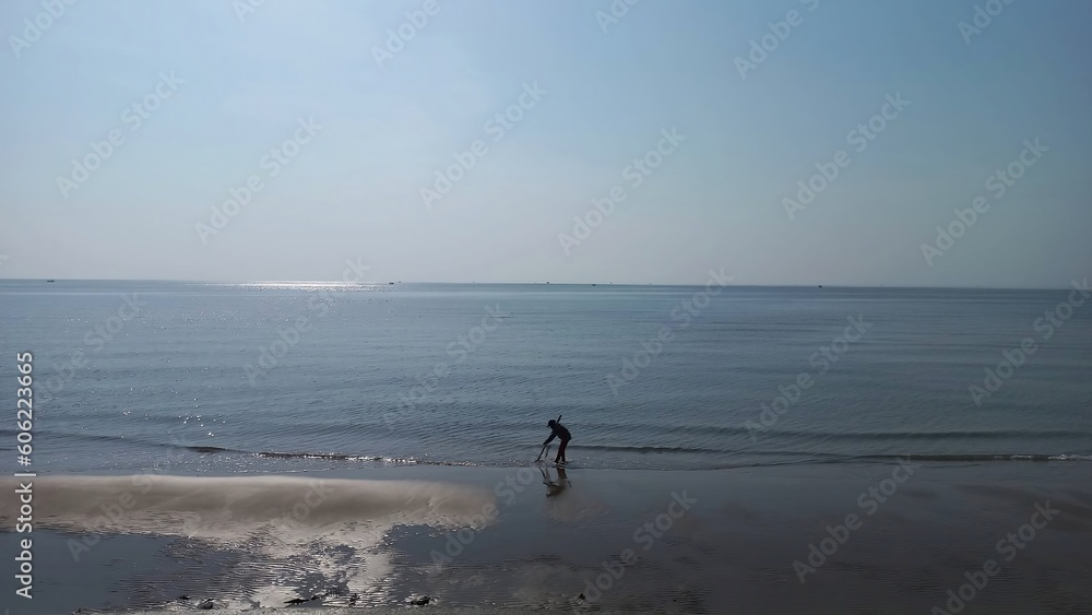 Coastal Charm: Captivating Beach with Fisherman for Sale on Adobe Stock