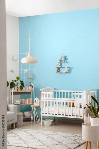 Interior of stylish bedroom with baby crib and shelving unit © Pixel-Shot