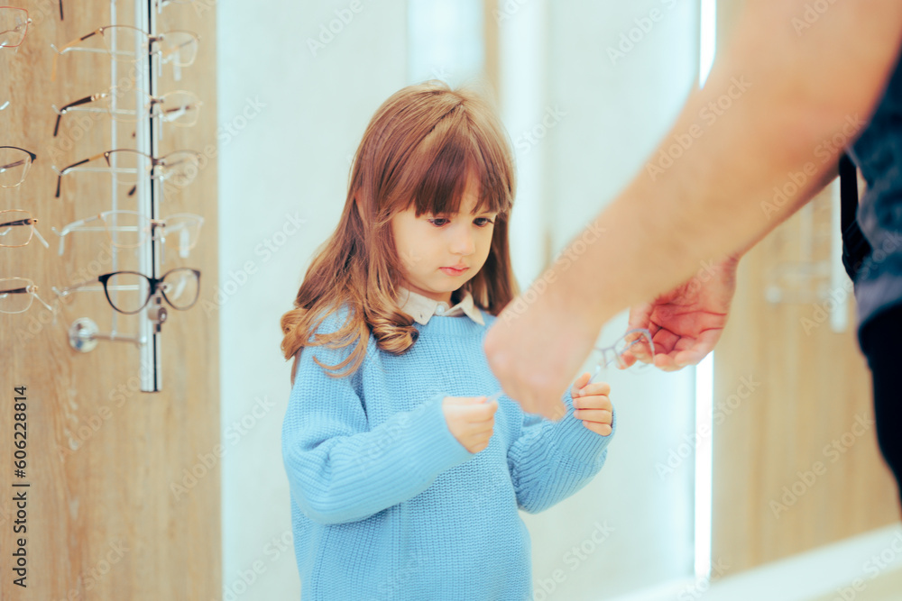 Optician Giving New Glasses to a Toddler Kid to Try on. Optometrist helping little girl to pick comfortable frames
Optician Giving New Glasses to a Toddler Kid to Try on. Optometrist helping little girl to pick comfortable frames