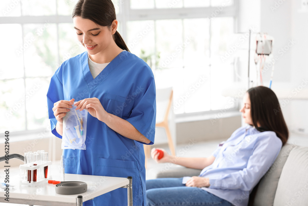 Female nurse with medical supplies for blood transfusion in clinic Female nurse with medical supplies for blood transfusion in clinic