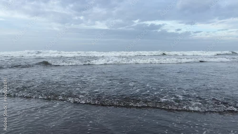 Soft wave of the ocean on Parangtritis Beach with black sand located in Yogyakarta, Indonesia. Soft wave of the ocean on Parangtritis Beach with black sand located in Yogyakarta, Indonesia.