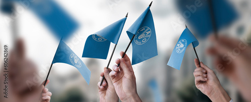 Billede på lærred A group of people holding small flags of the Food and agriculture organization i
