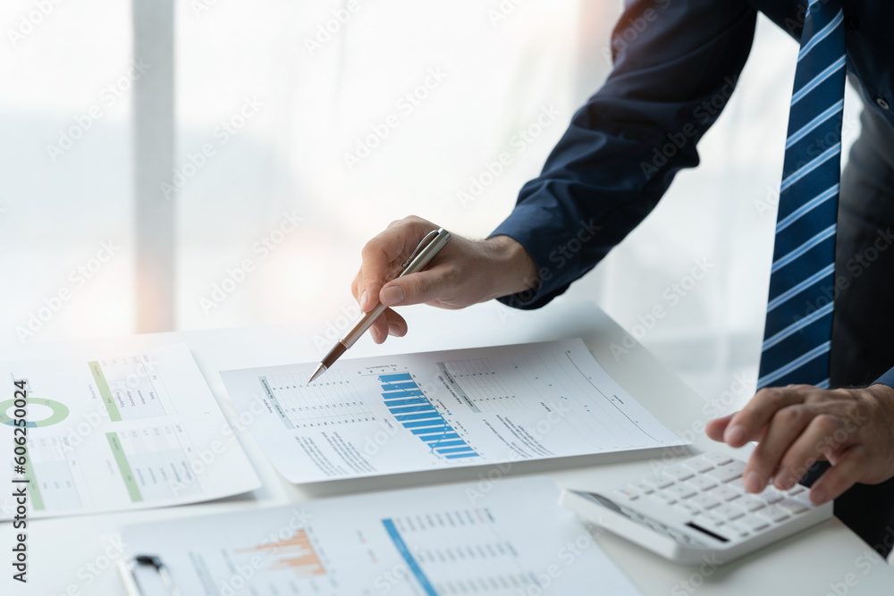 Businessman working in office using calculator to calculate numbers, financial accounting concept for company progress and growth management system concept finance and tax. Businessman working in office using calculator to calculate numbers, financial accounting concept for company progress and growth management system concept finance and tax.