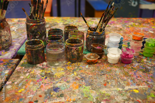 Paints and paint brushes in an artists studio.