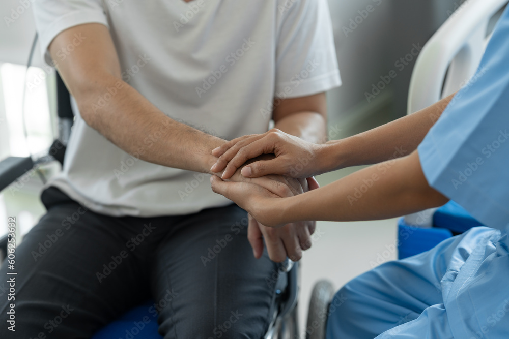 A psychologist or physiotherapist gives advice and encouragement to a male patient in a wheelchair suffering from pain to improve his mental state. The concept of health insurance, psychology. A psychologist or physiotherapist gives advice and encouragement to a male patient in a wheelchair suffering from pain to improve his mental state. The concept of health insurance, psychology.