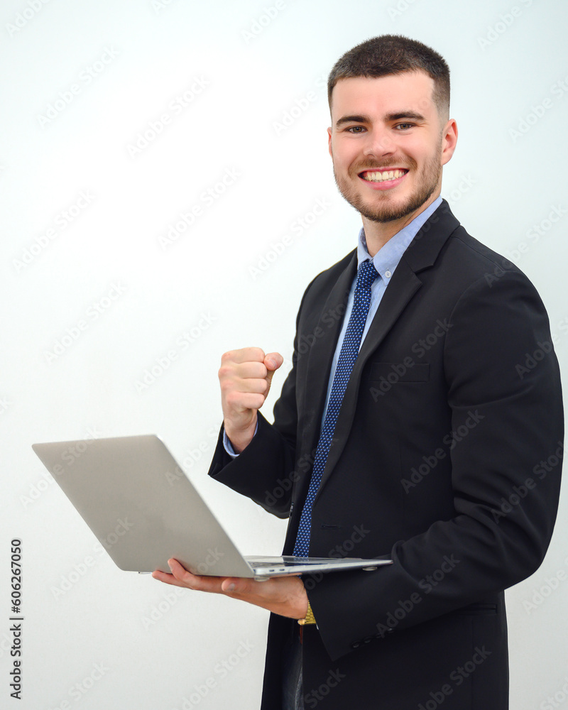Portrait of happy young businessman a successful business man holding a laptop Looking at the camera confident and smiling Isolated over white wall background Portrait of happy young businessman a successful business man holding a laptop Looking at the camera confident and smiling Isolated over white wall background