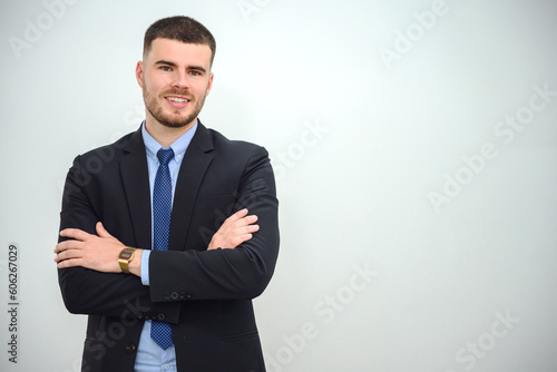 A happy young businessman Business man standing with crossed arms confident and smiling in the office white wall background