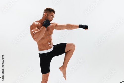 Man athletic bodybuilder poses in boxing gloves with nude torso abs in full-length background, boxing and martial arts. Advertising, sports, active lifestyle, competition, challenge concept. 