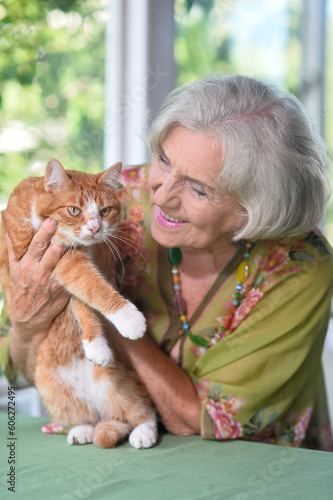 beautiful elderly woman holding a white cat  photo