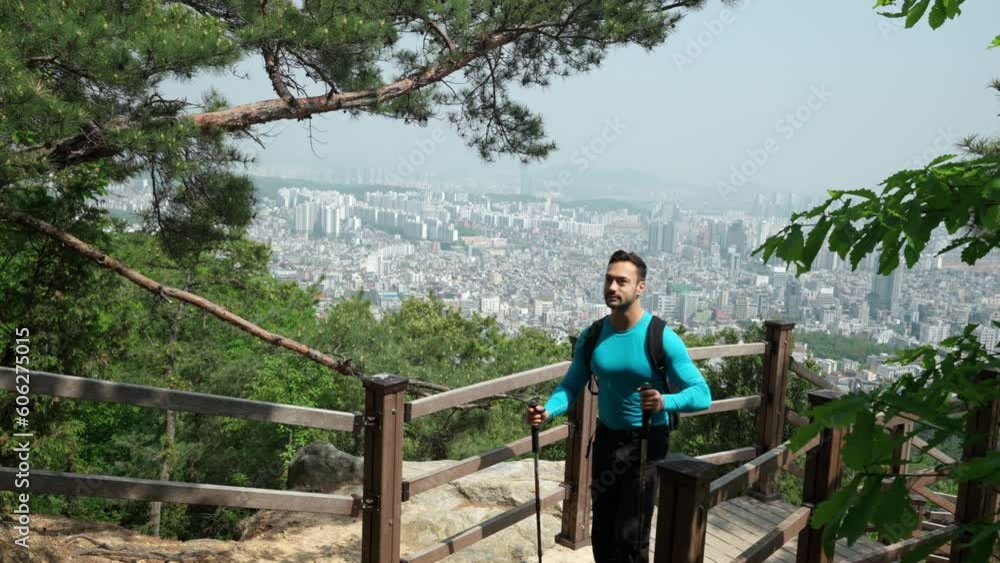 Caucasian Traveler Man Or Hiker Hiking in Gwanaksan Mountain Forest, Walks Up The Trail with Seoul City Panorama in Background. South Korea Travel Concept Caucasian Traveler Man Or Hiker Hiking in Gwanaksan Mountain Forest, Walks Up The Trail with Seoul City Panorama in Background. South Korea Travel Concept