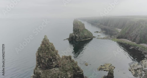 Slow drone panning across the sea showing the Stacks of Duncansby during misty and foggy weather along the Scotland North Coast 500 route at John O'Groats photo