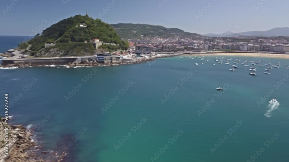 Aerial pan above bay entrance to San sebastian beach with boats anchored offshore Aerial pan above bay entrance to San sebastian beach with boats anchored offshore