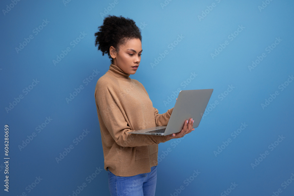successful young female student with swarthy skin and fluffy hair studying remotely using laptop on isolated background with copy space successful young female student with swarthy skin and fluffy hair studying remotely using laptop on isolated background with copy space
