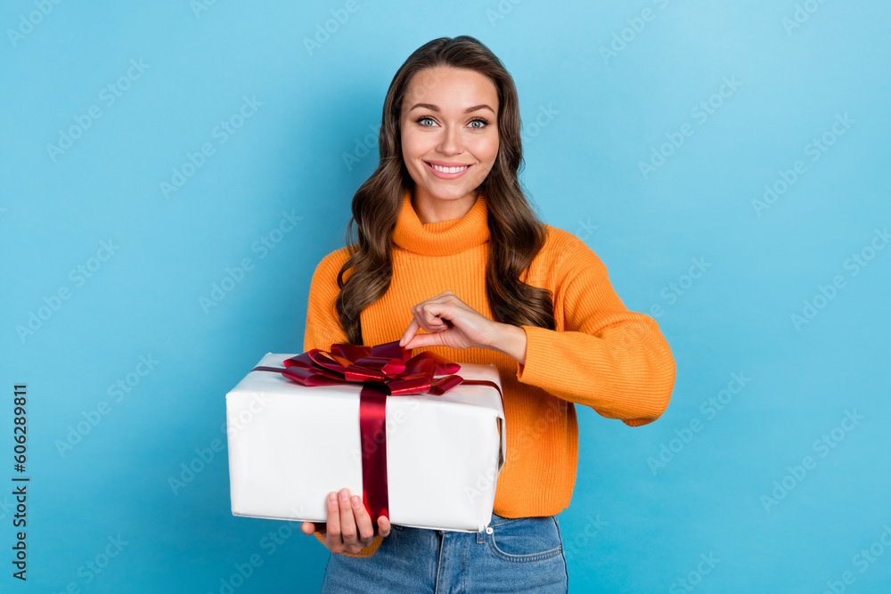 Photo of pretty charming woman dressed orange sweater smiling gift box isolated blue color background Photo of pretty charming woman dressed orange sweater smiling gift box isolated blue color background