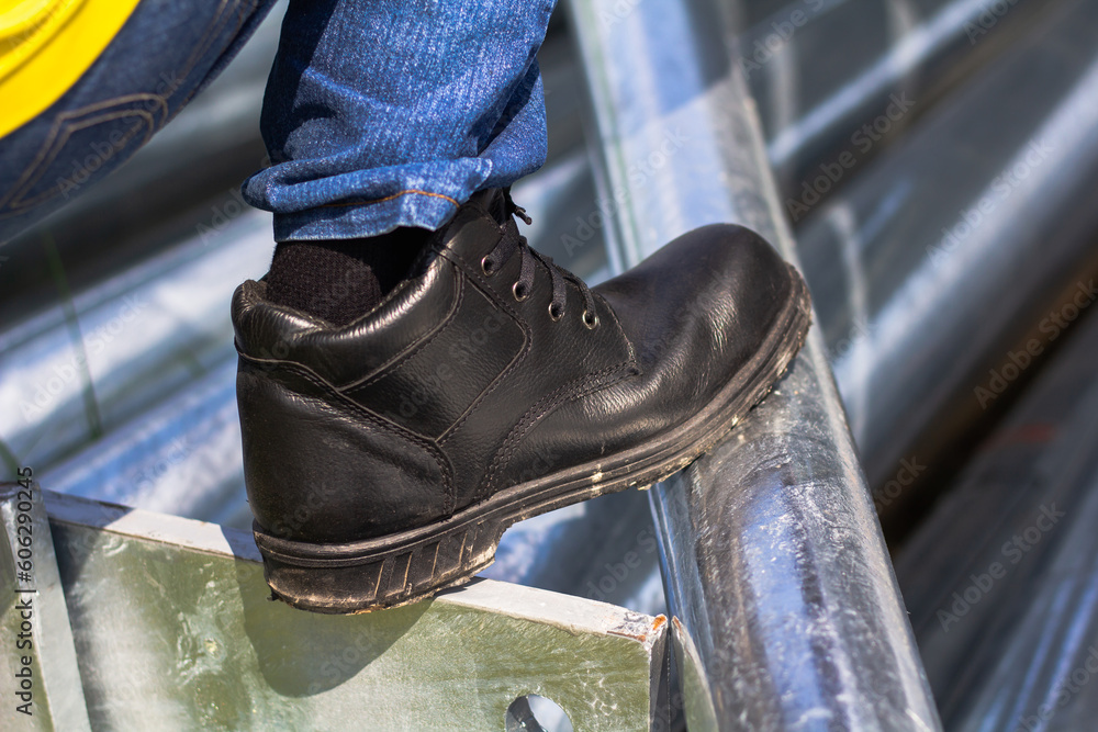 Wear safety shoes to ensure safety at work. construction workers wear safety shoes. People with