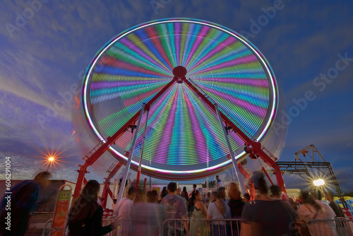 People waiting in line for the Ferris wheel at the state fair at night