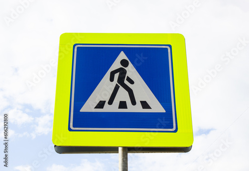 Close-up of a pedestrian crossing sign against the sky. Place for crossing the motorway, motorway for pedestrians.