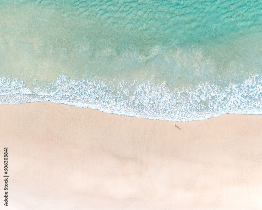 Beautiful beachside destinations pictured with sand, pristine blue water and gentle waves breaking on a beach Beautiful beachside destinations pictured with sand, pristine blue water and gentle waves breaking on a beach