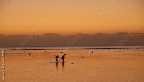 fishmen in the sea in the evening sunlight on the background of the sunset